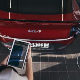 Mechaniker mit Tablet vor einem EV