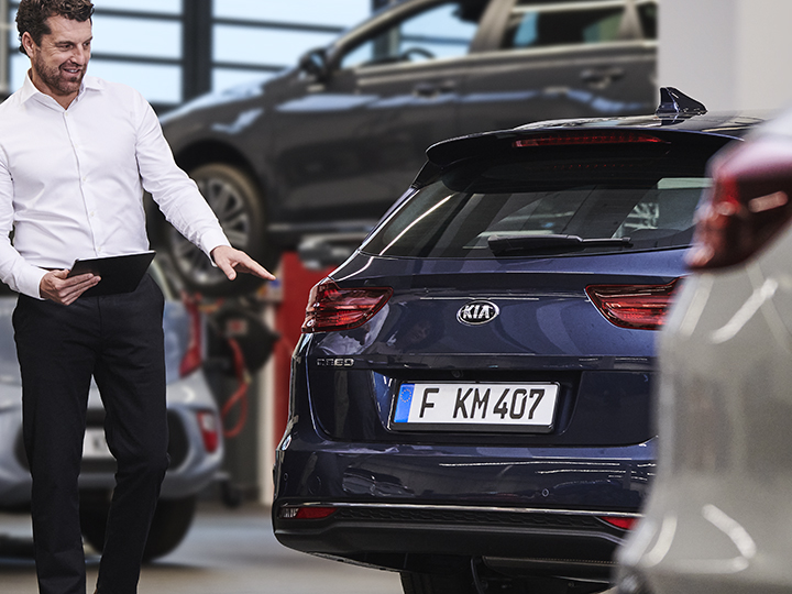 Mechanic shows the customer the damaged part of the car